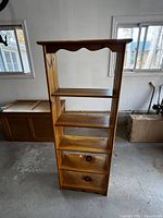 Front view of pine bookshelf showing five shelves and scalloped top