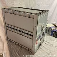 Two stacked grey plastic file cabinets, side view