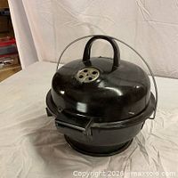 Closed grill showing carrying handle and vent