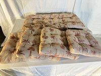 Five tufted palm-print cushions arranged on table