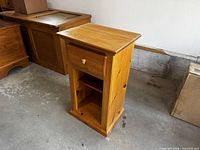 Front view showing drawer, shelf and natural pine finish