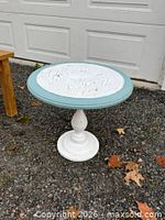 Full view of side table outdoors showing entire piece