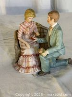 Front view of figurine showing couple during proposal