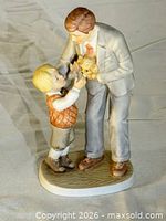 Front angle view of porcelain figurine father, son, puppy on oval base