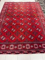 Full view of red Turkman rug showing overall pattern and size