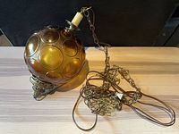 Full view of amber bubble glass globe lamp with chain
