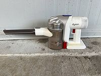 Full view of Dyson DC57 handheld vacuum with crevice tool attached