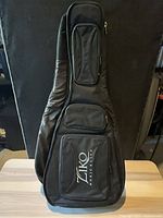 Front view of black Ziko guitar gig bag showing logo and pockets