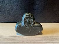 Front view of soapstone bust displaying facial features and hood