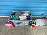 Overall view of laundry basket with Duplo blocks, pink side bin, small box of vehicles