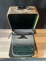 Typewriter inside open case showing full keyboard and exterior of case