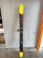 Full length view of ski showing graphics, bindings and tip/tail colors