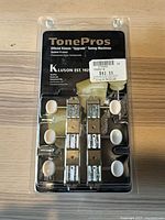 Front of sealed TonePros Kluson System II tuner pack showing six tuners and branding