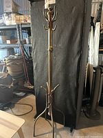 Full view of freestanding brass-tone coat rack