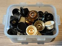 Overview of plastic box filled with assorted guitar knobs