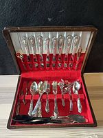 Full view of open flatware case showing utensils in lid and base