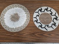 Two round platters showing white splash and black zigzag ring designs