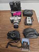 All four cameras, two cases, Capital box displayed on table