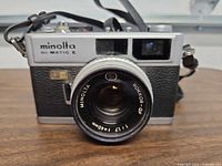 Front view showing Minolta Hi-Matic E branding and Rokkor-QF 40mm f/1.7 lens