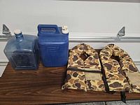 All items on table: two water jugs and two life jackets