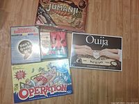 All five sealed board games displayed on floor