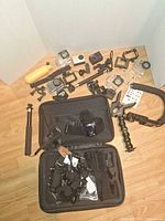 Group shot of cameras, housings, mounts, grips, selfie stick, carry case and accessories