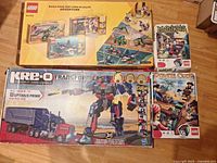 All four boxed construction sets displayed: LEGO Wildlife Adventure multipack, LEGO Games Magikus, LEGO Games Pirate Code and KRE-O Optimus Prime 542-piece set