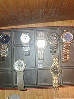 All seven wristwatches displayed in tray