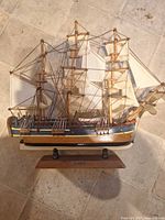 Full view of wooden three-masted model ship, starboard side, on display stand