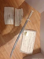 Full view of sword with two authentication papers