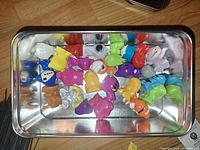 Open tin showing assorted Crazy Bones figures
