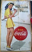 Full view of Coca-Cola cardboard sign showing tennis player, text, and damage
