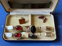 Open case showing five cufflink pairs, two shirt studs and interior lining