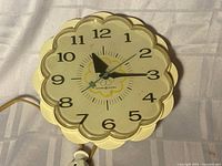 Front view of General Electric scalloped wall clock with cord