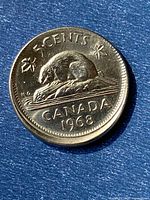 Reverse side of 1968 Canadian 5-cent coin showing beaver and off-centre rim