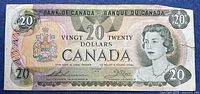 Front of 1979 Canadian $20 bill showing Queen Elizabeth II, signatures, serial number, visible tear