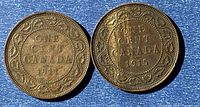 Reverse sides of 1911 and 1915 Canadian one-cent coins on blue background