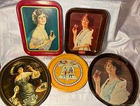 Group shot of five metal advertising trays