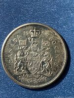 Obverse of 1964 Canadian 50 cent silver coin showing Canadian coat of arms and date