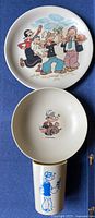 Plate, bowl and cup with Popeye graphics displayed vertically
