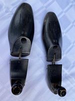 Pair of black adjustable shoe stretchers with knobs