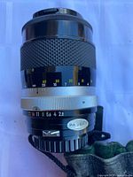 Side view of Nikon telephoto lens showing focus grip, aperture ring, and markings