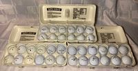 Three open egg cartons holding 36 golf balls
