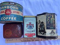 Group shot of all four tins next to ruler