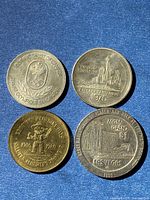 Four coins: Olympic Trust, Calgary Centennial 1975, Alberta 75th Anniversary, MGM Grand $1 1980