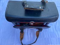 Closed top view of leather camera case with strap and handles