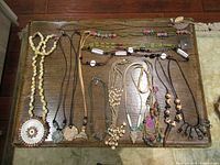 All 14 necklaces laid out on table for full inventory view