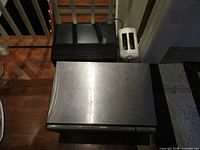 Top view of black microwave, stainless microwave, white toaster