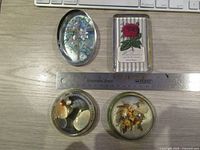 All four resin paperweights grouped beside ruler for scale