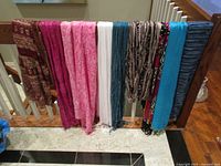 All nine scarves draped over railing showing colors and patterns